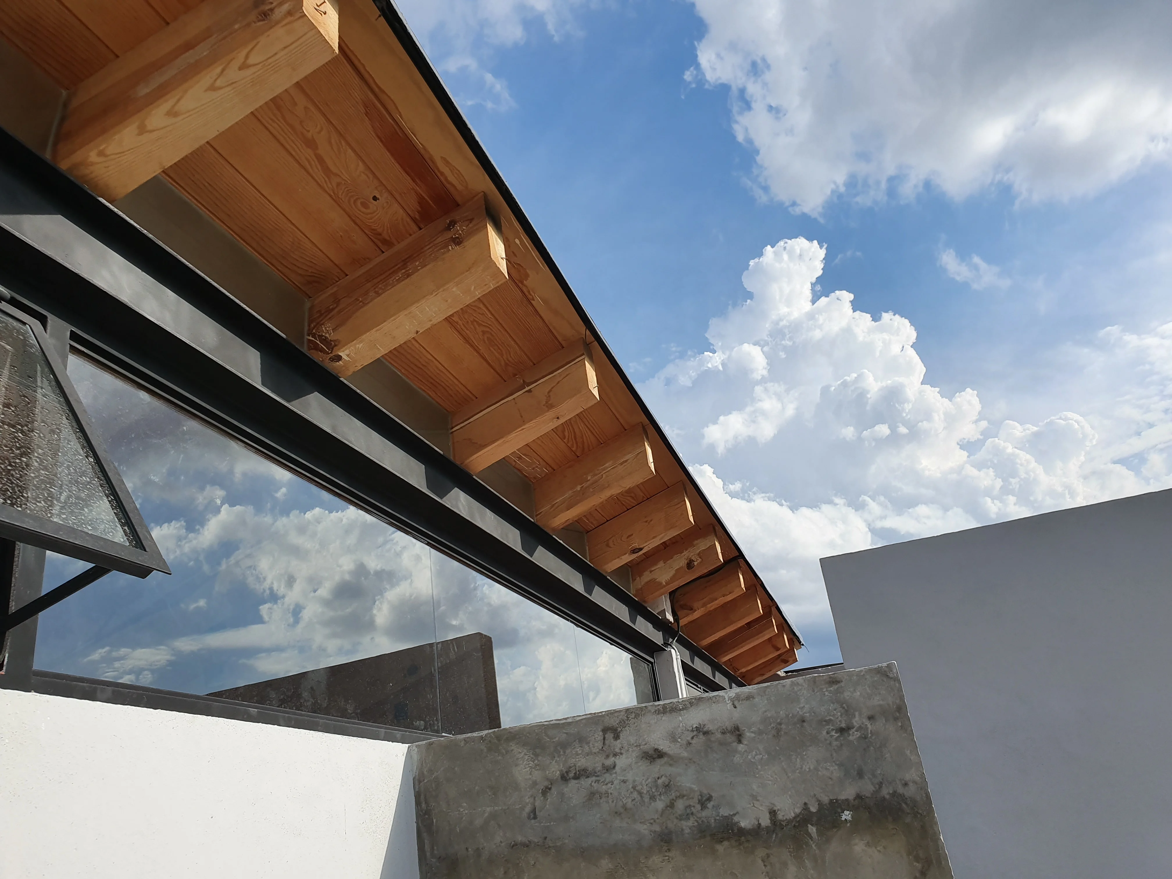 Fachada moderna de Casa Thies con doble altura, concreto expuesto y amplios ventanales de vidrio.