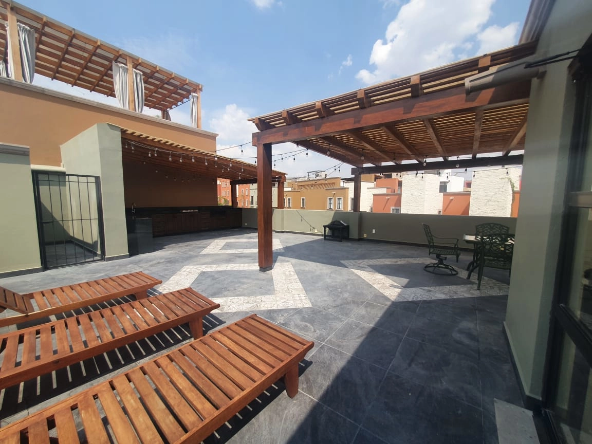 Terraza exterior ampliada con pérgolas y barra de asador en el proyecto El Milagro, San Miguel de Allende.